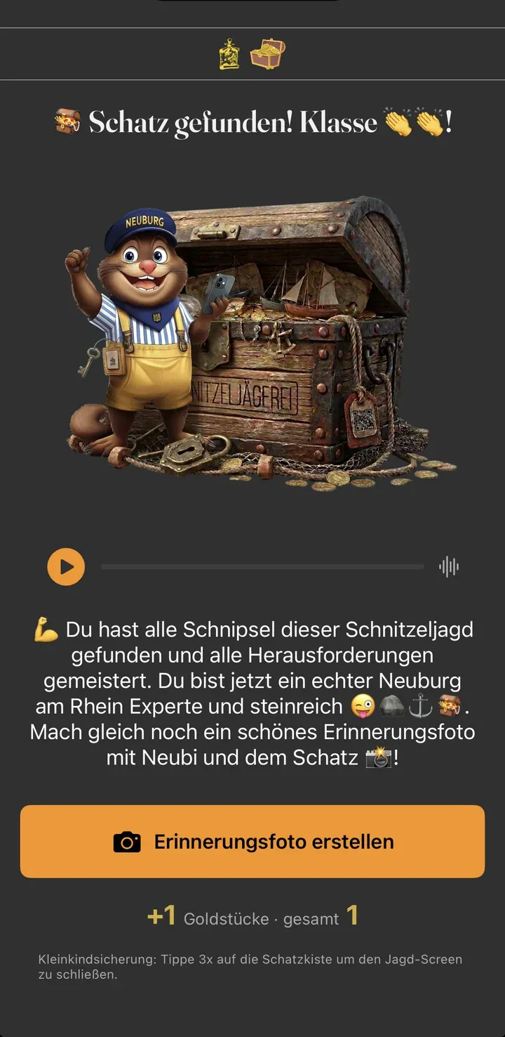 Erfolgs-Screen im Spiel: Maskottchen Neubi an der geöffneten Truhe, Gratulationstext, Button „Erinnerungsfoto erstellen“